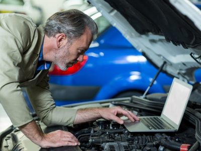 mechanic-using-laptop-while-servicing-car-engine_1170-1304